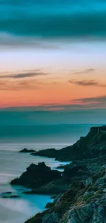 Stunning sunset view over rocky cliffs and ocean with vibrant sky hues.