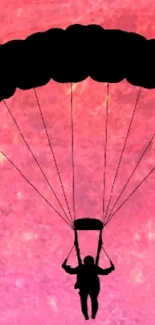 Silhouette of parachute in front of a pink planet with cosmic background.