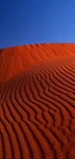 A stunning orange desert dune under a deep blue sky, perfect for mobile wallpaper.