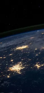 Night view of Earth from space with glowing city lights.