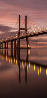 A stunning dusk view of a lit bridge with water reflection and colorful sky.