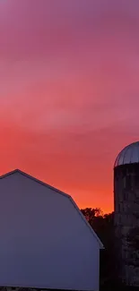 Farm at sunset with vibrant orange sky.