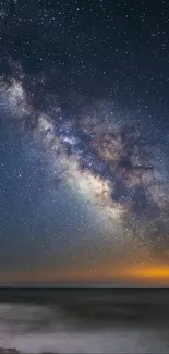 Galaxy over ocean under starry night sky.