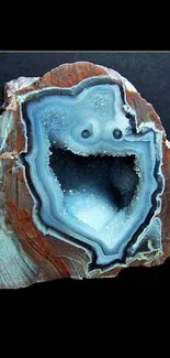 Brown geode with blue crystal center on dark background.