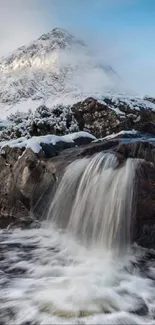 A serene waterfall in the snowy Scottish Highlands landscape.