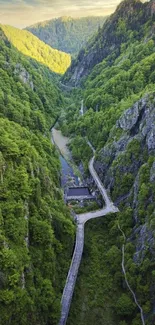 Aerial view of a lush green valley with winding pathways against rugged mountains.