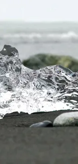 Crystal-clear ice on a black sand beach with ocean waves.