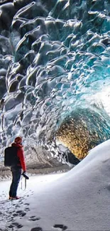 Person standing in stunning Iceland ice cave with icy blue tones.