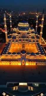 Aerial view of a beautifully illuminated mosque against a night cityscape backdrop.