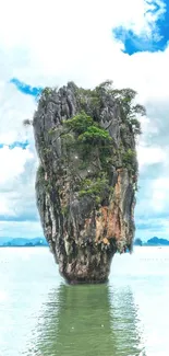 Steep island rock in tranquil sea under a bright sky.