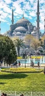 Istanbul's Blue Mosque amidst gardens and tourists on a sunny day.