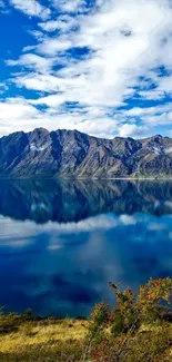 Mountain lake reflected under blue sky wallpaper.