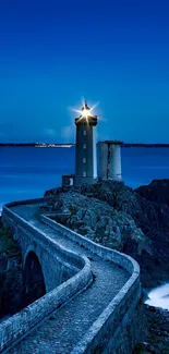 Lighthouse glowing at twilight on coastal cliff with stone path.