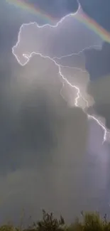 Lightning strikes with a rainbow in the cloudy sky.