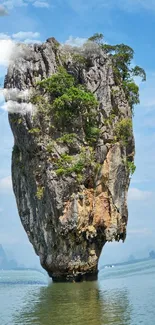 Limestone island rising from ocean with lush greenery.