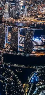 Aerial view of Marina Bay at night with illuminated buildings and skyline.