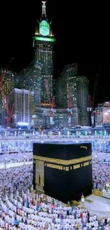 Kaaba at night surrounded by city lights and worshippers.