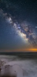 Milky Way arching over a tranquil ocean under a starry night sky.