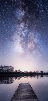 Milky Way over lake with wooden dock at night.