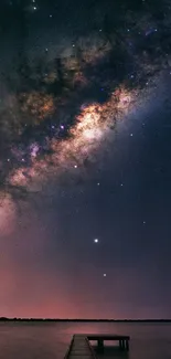 Milky Way galaxy over the ocean horizon at night.