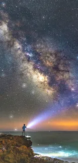 A person gazing at the Milky Way against an ocean backdrop under a starry sky.