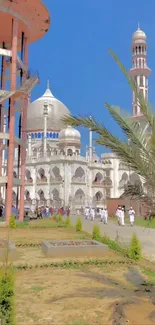 Vibrant mosque view with palm trees under a clear blue sky.