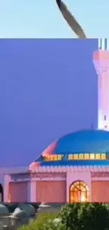 Dusk view of a mosque with blue dome and vibrant purple sky.