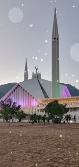 Mosque at dusk with colorful lighting and mountains in the background.