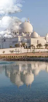 Mosque reflected in calm water under a clear blue sky.