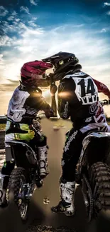 Motocross riders at sunset on dirt bikes.