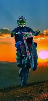 Motocross rider jumping at sunset with mountains in the background.