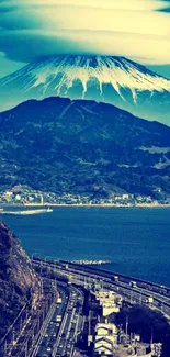 Scenic wallpaper featuring Mount Fuji with a coastal highway and blue skies.