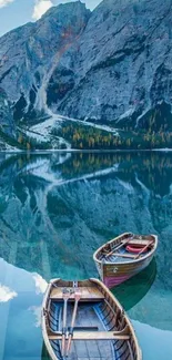 Serene mountain lake with wooden boats reflecting in clear blue water.