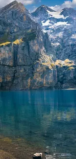 Serene mountain lake with snow-capped peaks under a blue sky.