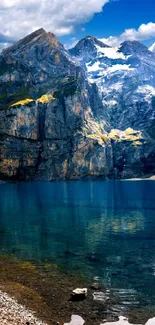 Majestic mountain range with lake reflecting under blue skies.