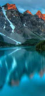 Serene mountain lake with blue water and rocky peaks at sunset.