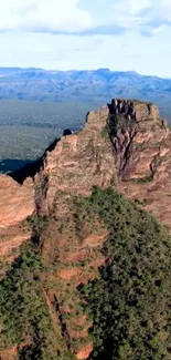 Mountain landscape with rugged cliffs and greenery.