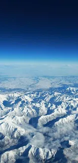 Aerial view of snow-covered mountains with a deep blue sky.