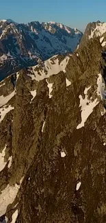 Mobile wallpaper of a rugged mountain ridge with snow.