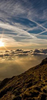 Mountain sunrise with vibrant sky and sun illuminating clouds.