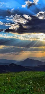 Mountain sunrise with vibrant rays and clouds.