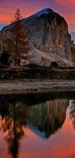 Mountain sunset reflected in serene lake with vibrant colors.