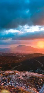 Vibrant sunset over mountain landscape with dramatic skies.