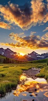 Sunset over mountains with a reflective stream and green fields.