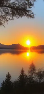 Mountain sunset over lake with orange glow and reflections.