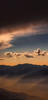 Sunset over misty mountains with dramatic clouds.