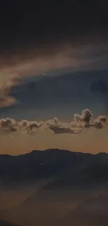 Silhouetted mountains at sunset with golden clouds in a dramatic sky.