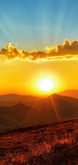Beautiful sunset over mountains with vibrant orange sky.