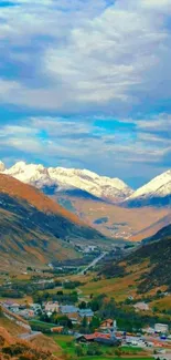 A stunning mountain valley view with snowy peaks and a vibrant blue sky.