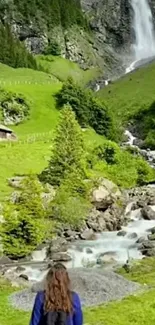 Mountain waterfall with lush green landscape and clear blue sky.